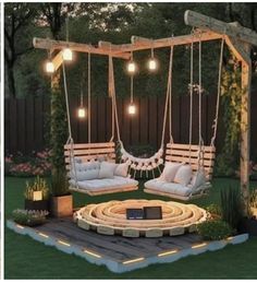 an outdoor swing chair with lights hanging from it's sides and some pillows on the ground