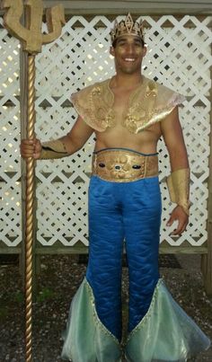 a man in blue and gold costume holding a pole with an anchor on it's side