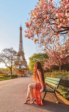 a woman sitting on a bench in front of the eiffel tower