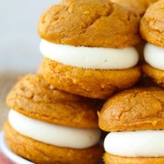 a pile of cookies with white frosting and pumpkin pie fillings on the top