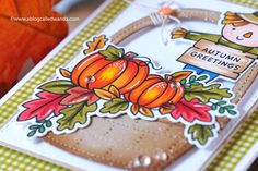 a close up of a card with an orange pumpkin and a person holding a sign that says autumn greetings