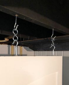 two metal chains are hanging from the ceiling