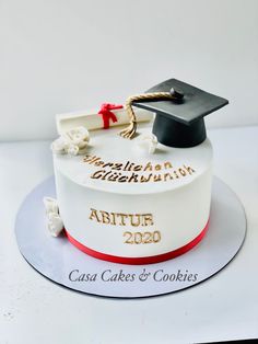 a graduation cake is decorated with white and red icing