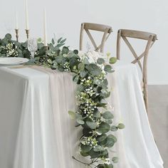 the table is decorated with greenery and candles