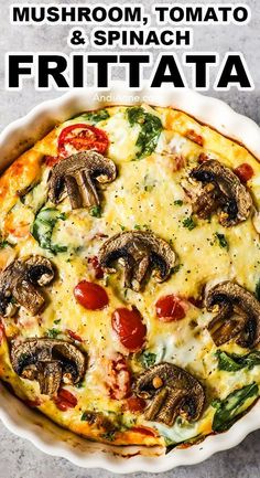 a pizza with mushrooms, tomatoes and spinach on it in a white pie dish