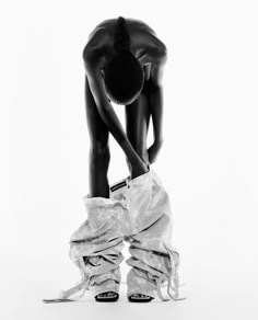 a black and white photo of a person bending over