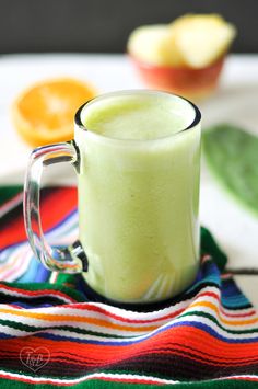 a green smoothie in a glass mug on a colorful towel