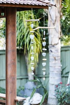 a wooden gazebo with stones hanging from it