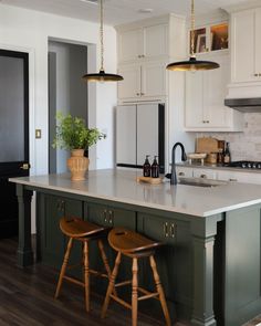 a kitchen island with two stools next to it