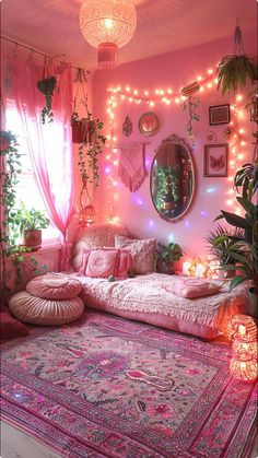 a living room filled with lots of pink furniture and lights hanging from the ceiling above it