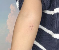 a person with a small star tattoo on their left arm and the other arm behind her