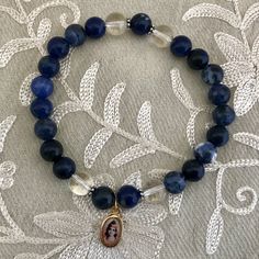 The Krishna Wrist Mala Bracelet reminds us of the evening sky. The color of Sri Krishna. - Made of deep blue Sodolite, clear Quartz crystal, Sterling Silver findings and a tiny charm of Bhagavan Krishna. Sodalite is known to aid in rational thought, facing truth and dealing it with objectivity and vocalization of ones feelings. Quartz Crystal is known as the “Great Healer” for its ability to absorb, store, release and regulate energy. It also is known to enhance the qualities of the other gemsto Bhagavan Krishna, Krishna Bracelet For Women, Spiritual Blue Hand-strung Bracelets, Hand-strung Blue Spiritual Bracelets, Adjustable Hand-strung Blue Rosary Bracelet, Adjustable Blue Hand-strung Rosary Bracelet, Sri Krishna, Wrist Mala, Tiny Charm