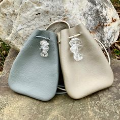 two small purses sitting on top of a rock