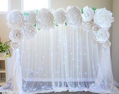 a white curtain decorated with flowers and lights