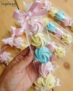 a person is holding some small cupcakes in a package with ribbons on them