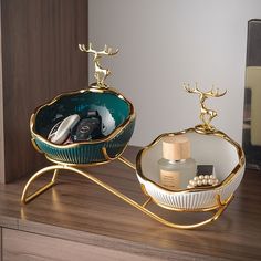 two decorative items sitting on top of a wooden table next to a mirror and shelf