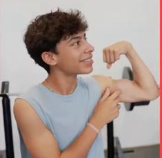 the young man is flexing his arm muscles