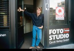 a man standing in the doorway of a building with his hand out and pointing at something