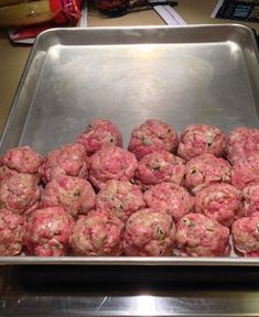 a metal pan filled with meatballs on top of a counter