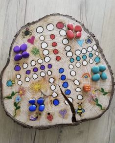 a wooden board game sitting on top of a piece of wood covered in lots of different colored buttons