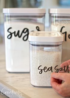 two containers with sea salt in them sitting on a counter