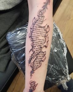 a person with a tattoo on their arm that has words written in different languages and shapes