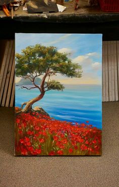 an oil painting of a tree and red flowers by the ocean with water in the background