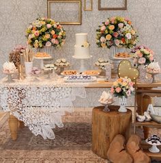 a table topped with lots of cakes and desserts next to pictures on the wall