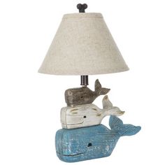 a lamp that is sitting on top of a wooden block with a whale underneath it