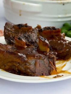 a white plate topped with meat covered in sauce