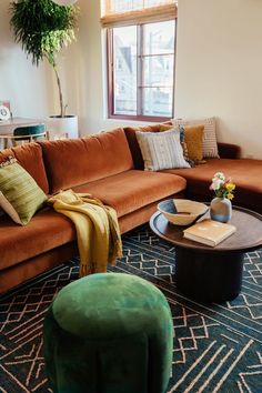 a living room filled with furniture and a large mirror on the wall above it's windows