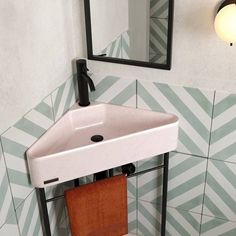 a white sink sitting under a bathroom mirror next to a wooden towel rack on top of a tiled wall