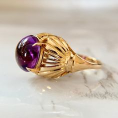 True Art Deco large Amethyst cabochon ring handmade from 18K yellow gold. Stunning domed setting with lovely detail! The underside of the stone is faceted, giving it a great look from the top. Hallmarked and tested. Size 6.25 and sizable upon request for an additional charge. We are a brick and mortar store located in Alhambra, CA. All of our items are guaranteed as described. SPECIFICATIONS: Size: 6.25 Amethyst: 10mm x 9mm Total Weight: 6.78 grams   This ring has been inspected by professionals with over 35 years of experience to ensure its excellent condition. **Please inquire about sizing before purchase or making an offer. Order will ship within 24 hours. We offer a 14-day, no-questions-asked return policy. Please see detailed pictures, as they are part of the description, and do not h Collectible Oval Cabochon Amethyst Ring, Gold Amethyst Oval Cabochon Ring, Oval Yellow Gold Amethyst Ring With Polished Finish, Oval Amethyst Ring In Yellow Gold With Polished Finish, Yellow Gold Amethyst Cabochon Ring, Gold Amethyst Ring With Cabochon Cut, Yellow Gold Amethyst Ring With Polished Finish, Heirloom Amethyst Ring In Yellow Gold With Bezel Setting, Yellow Gold Oval Cabochon Dome Ring With Gemstone