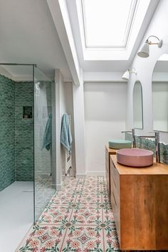 a bathroom with a skylight above the sink and shower stall, along with a wooden cabinet