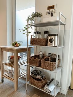 a shelf filled with lots of kitchen items next to a wooden table and windowsill