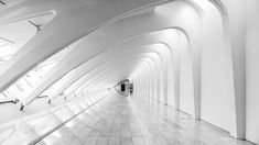 a black and white photo of the inside of a subway station with many curved walls