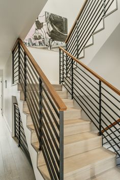 a staircase with metal railing and wood handrails