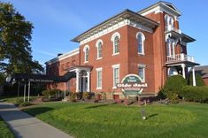 an old red brick building with a sign in front