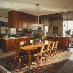 a wooden table surrounded by chairs in a living room next to an open kitchen and dining area