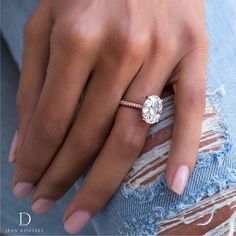 a woman's hand with a diamond ring on her finger