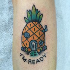 a small pineapple tattoo on the left leg with an i'm ready message