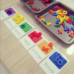 two trays filled with letters and numbers on top of a table next to each other