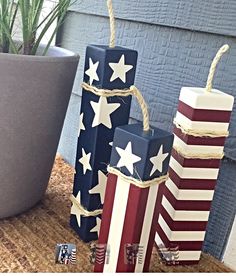 three patriotic boxes are sitting on a table next to a potted plant, and one is wrapped in twine