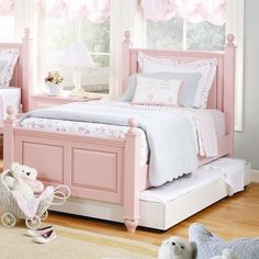 there is a pink bed in the room with two teddy bears on the floor next to it