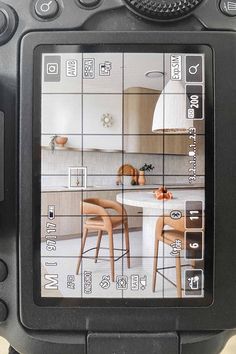 a digital camera with an image of a kitchen and dining room on the screen in front of it