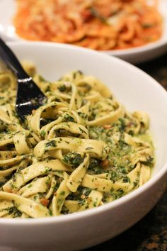 two bowls filled with pasta and spinach sauce