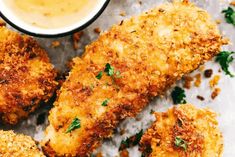 fried fish sticks with dipping sauce and parsley sprinkled on the side, ready to be eaten