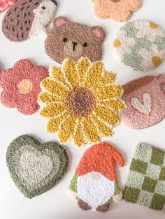 crocheted teddy bears and flowers on a white surface