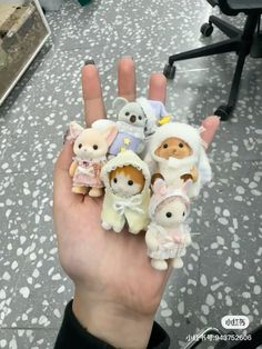 someone is holding small stuffed animals in their hand