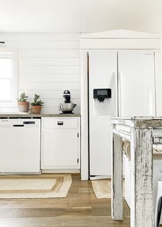 a kitchen with white appliances and wood floors